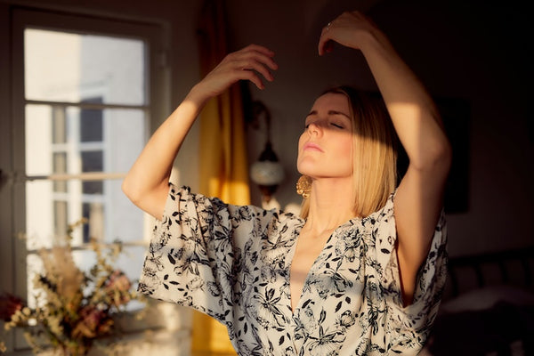 woman practicing a breathing exercise to improve skin health